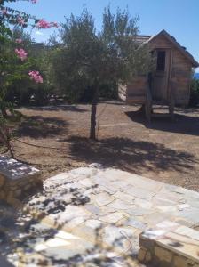 a backyard with a tree and a stone patio at Nicolas Apartments in Ierapetra