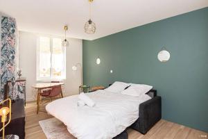 a bedroom with a large bed with a blue wall at ART & DECO - STUDIO COEUR DE VILLE in Agen