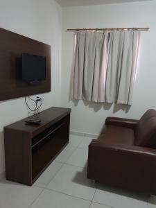 sala de estar con sofá y TV en Condomínio João Bezerra II, en João Pessoa