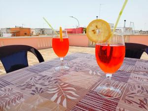 tres copas de vino sentadas en una mesa con una rodaja de limón en Casa vacanze Fabrizio, en Andrano
