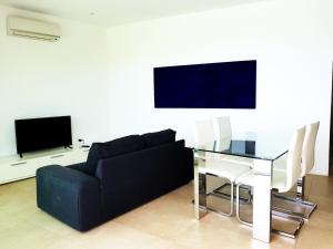 a living room with a black couch and a glass table at Le Villette in Cittadella del Capo