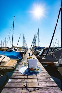 a table with a plate of food on a dock with boats at Yachthotel Chiemsee GmbH in Prien am Chiemsee