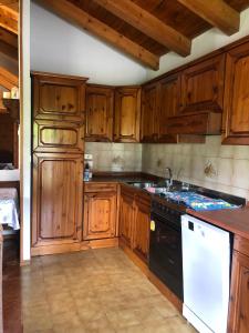 - une cuisine avec des placards en bois et un lave-vaisselle blanc dans l'établissement Appartamenti Il Castello, à Saint-Pierre