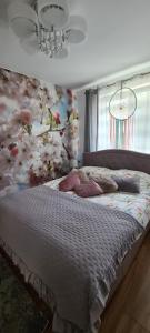 - une chambre avec un lit orné de fleurs sur le mur dans l'établissement Apartament na wydmie u Eli, à Ustka