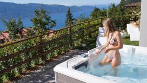 a young girl in a bathing suit standing in a bath tub at La Terrazza sul Lago, Tignale in Tignale