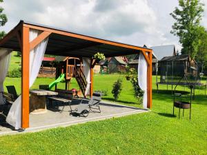 a pavilion with a table and chairs in a yard at U Sobali in Groń