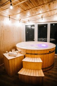 a large tub in a wooden room with two benches at Ceprówka Family Friendly in Białka Tatrzańska