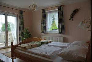 Bett in einem Schlafzimmer mit Fenster in der Unterkunft Landhaus Neubauer in Millstatt