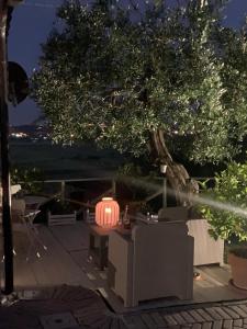 una linterna sentada en una mesa bajo un árbol por la noche en Locazione turistica Casa olivo en Fucecchio