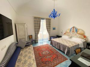 a bedroom with two beds and a tv and a rug at Palazzo Marzoli charme Resort - Small Luxury Hotel in Positano