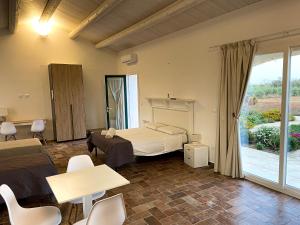 a bedroom with a bed and a table and chairs at PODERE CARAFA in Nardò +42 photos