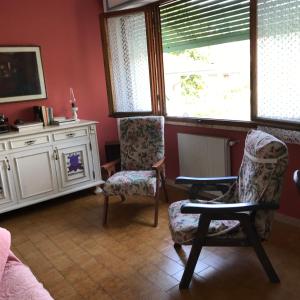 a living room with two chairs and a window at Il semaforo Appartamento a due passi dal centro di Pietrasanta in Pietrasanta