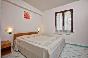 A bed or beds in a room at L'Oasi di Ottiolu