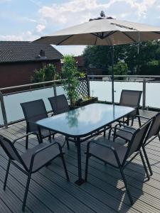einen Tisch und Stühle mit einem Sonnenschirm auf einer Terrasse in der Unterkunft Apartment Auszeit in Isenbüttel