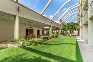 a courtyard of a building with green grass at Clarion Hotel Broken Arrow - Tulsa in Broken Arrow