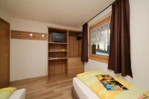 a small room with a bed and a window at Danubio - Happy Rentals in Livigno