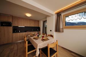 una cucina con tavolo, sedie, tavolo e tavolo di Danubio - Happy Rentals a Livigno