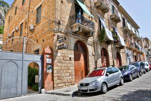 a row of cars parked next to a building at Sunny Flat - SELF Apartments in Cefalù