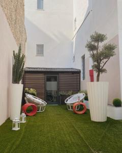 un patio con césped verde y sillas y un edificio en Casa Del Profumo, en Piacenza