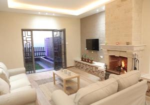 a living room with a couch and a fireplace at Dar Gerasa chalets The THREE Palm in Jerash