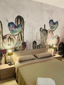 a bedroom with a bed with a mural of cactus at Casetta San Domenico apartment in Monopoli