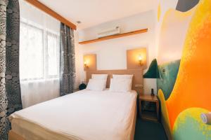 a small room with a bed and a window at Inn OZZ Astana in Astana