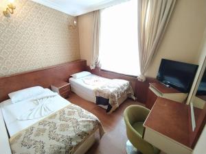 a hotel room with two beds and a television at Turvan Hotel in Istanbul