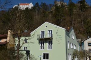 a white building with a balcony in front of a mountain at Forst´s Landhaus in Riedenburg