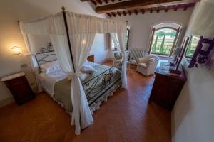 a hotel room with a bed, table and chairs at Agriturismo Castello La Grancia di Spedaletto in Pienza