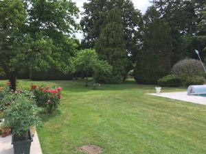 ein Park mit einem Rasen mit Blumen und Bäumen in der Unterkunft LES PORTES DE BOURGOGNE in Serbonnes