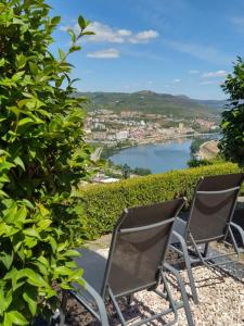 Dos sillas sentadas en una colina con vistas al río en Mito's House & Douro View, en Peso da Régua