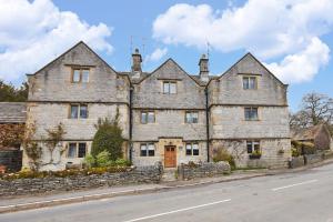 an old stone house on the side of a road at Postman's Knock in Hassop