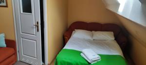a bedroom with a bed with two towels on it at Pokoje i kwatery w Augustowie in Augustów