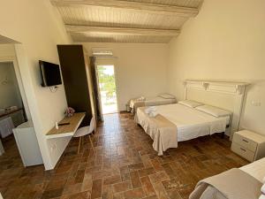 a hotel room with two beds and a television at PODERE CARAFA in Nardò