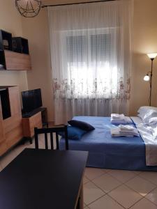 1 dormitorio con cama, mesa y ventana en Casa di Tiziana, en Anzio