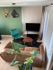Una sala de estar con un sofá y un televisor. en duplex proche gare vue tour Perret avec parking gratuit, en Amiens