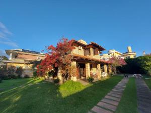 una casa grande con un árbol en el patio en Casa para 10 pessoas a 150m da praia - C130, en Florianópolis