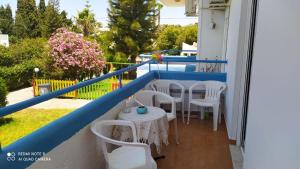 a balcony with tables and chairs on a house at Giovanni Apartment 21 Kos in Kos Town