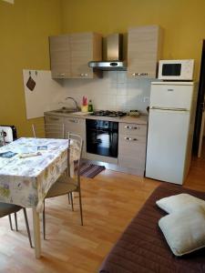 una cucina con tavolo e frigorifero bianco di Appartamento Libeccio a Finale Ligure