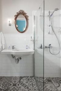 a white bathroom with a sink and a shower at 7 Brothers Hotel in Poros