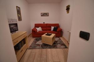 uma sala de estar com um sofá vermelho e uma caixa em CASA DEFLORIAN em Tesero