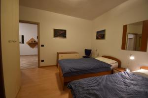 um quarto com duas camas e uma porta para um corredor em CASA DEFLORIAN em Tesero