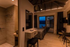 a bedroom with a bed and a bathroom with a view at Lighthouse Apartments in Stoupa
