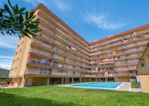 an apartment building with a swimming pool in front at HomeHolidaysRentals Bonte in Malgrat de Mar