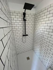 a bathroom with a shower with white brick walls at duplex proche gare vue tour Perret avec parking gratuit in Amiens