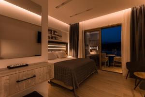 a bedroom with a bed and a large television at Lighthouse Apartments in Stoupa