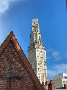 a tall building with a clock tower in the background at duplex proche gare vue tour Perret avec parking gratuit in Amiens