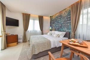 ザダルにあるVilla Manda Zadar Luxury Apartmentsのベッドとテーブルが備わるホテルルームです。