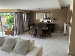 a living room with a couch and a table with chairs at Boothuis Ter Vaart in Blankenberge