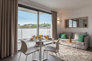 een woonkamer met een tafel en stoelen en een bank bij Lagrange Apart'Hôtel Antibes Olympie in Antibes